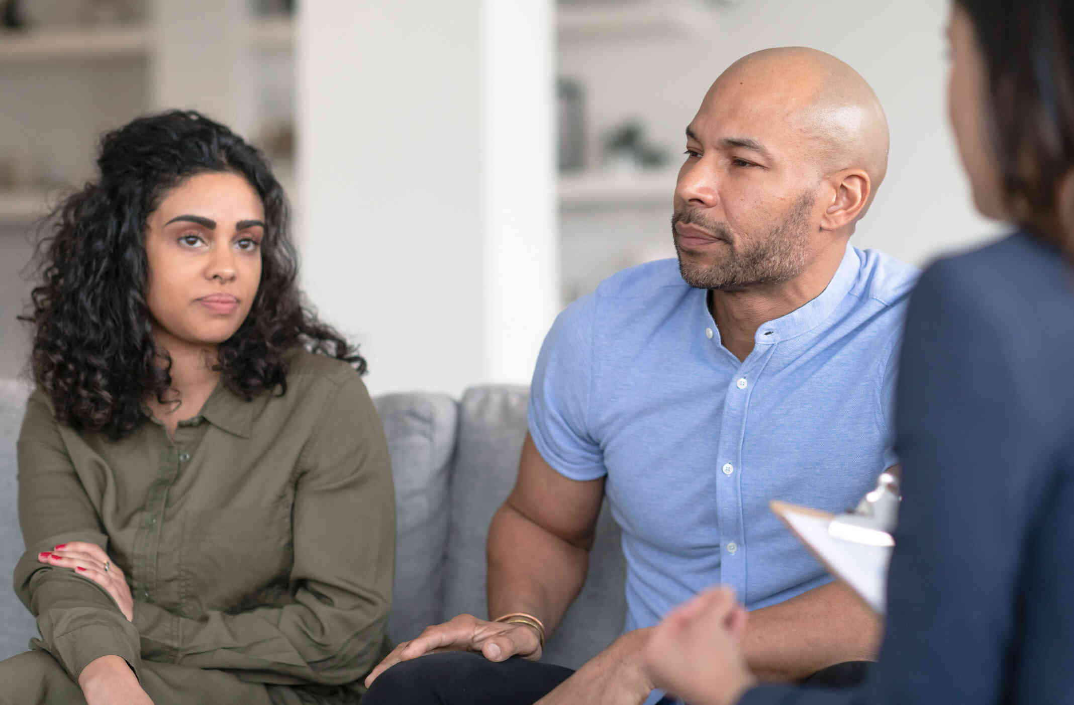 A couple looking distressed, attends a therapy session.